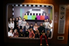 Grupka dzieci w Funzeum w Gliwicach - dzieci siedzą w wielkim telewizorze