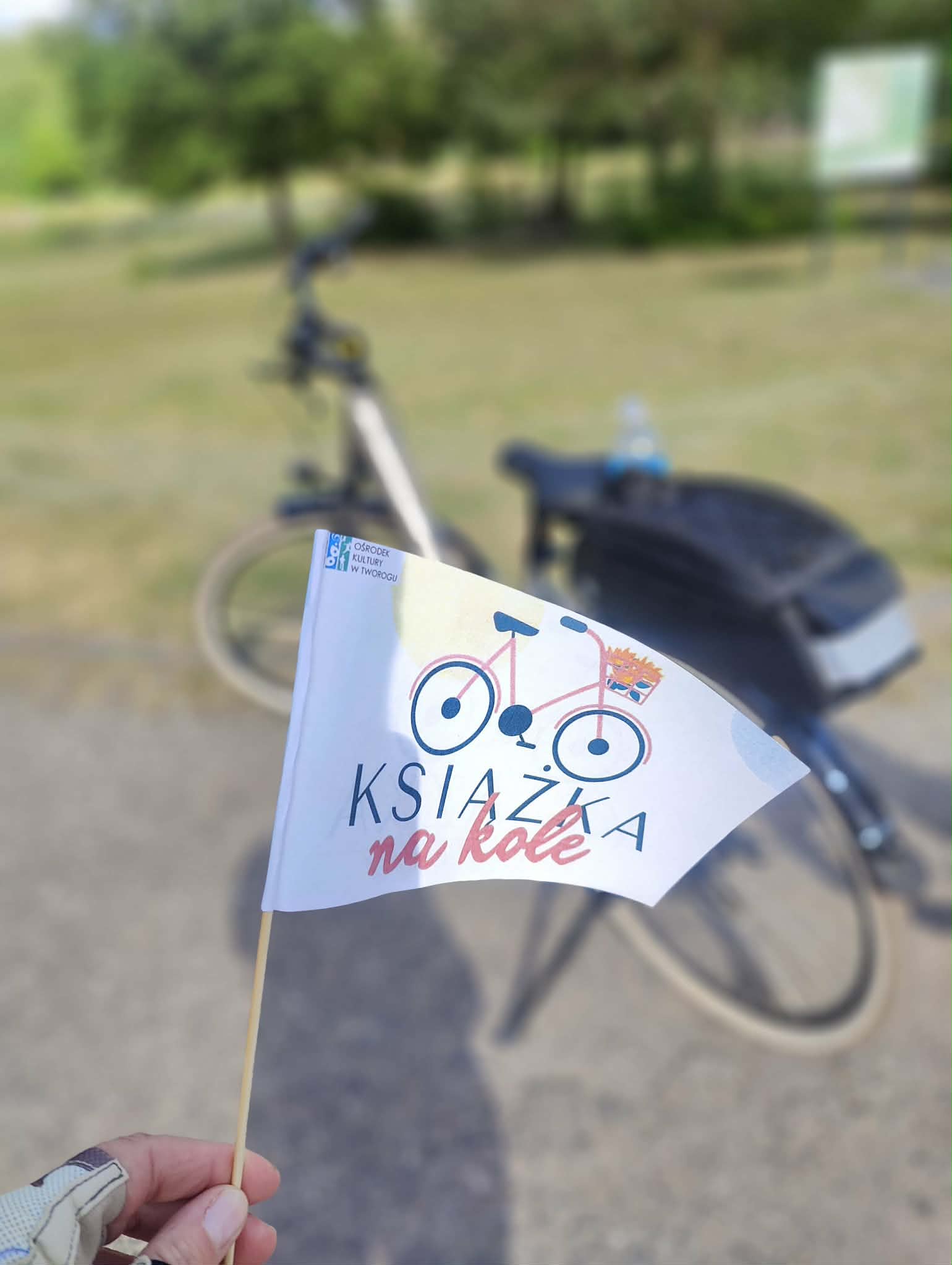 białe flaga z hasłem Książka na kole w tle rower